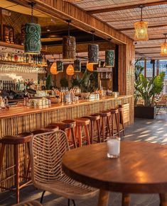 an outdoor bar with wicker chairs and wooden tables