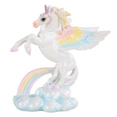 a white unicorn figurine sitting on top of a cloud filled with rainbows