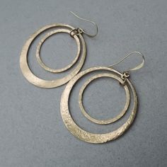 These Full Circle Earrings in hand hammered brass add a unique touch of elegance to your style. The look of gold but a fraction of the price! FEATURES • beautiful boho style Circle Earrings in Hand Hammered Textured Brass• brass wire and brass circles• brass ear wires• drop 2.5 inches (6.5cm), width 1.75 inches (4.5cm) Modern Handmade Metal Hoop Earrings, Metal Open Circle Earrings For Everyday, Everyday Metal Open Circle Earrings, Nickel Free Open Circle Metal Earrings, Modern Handmade Open Circle Earrings, Elegant Hand Forged Brass Hoop Earrings, Handmade Modern Open Circle Earrings, Hand Forged Brass Circle Earrings, Metal Open Circle Earrings