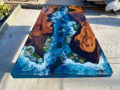 a coffee table made out of wood and glass with water running down it's sides