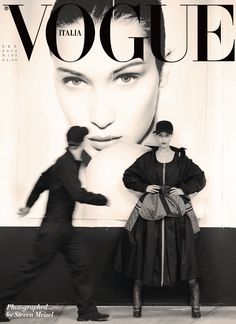 a man and woman standing in front of a magazine cover with an advertisement for the italian fashion brand