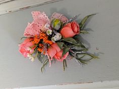 a bouquet of flowers is hanging on the side of a wall with lace and crochet