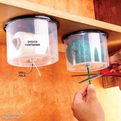 two plastic containers with yarn and scissors hanging from the ceiling next to each other on a wooden shelf