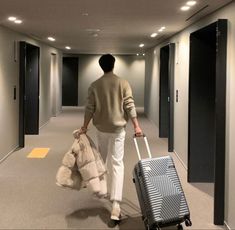 a man is walking down the hallway with his luggage