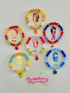 six bracelets with cartoon characters on them are shown in different colors and sizes, along with the words strawberry shortcake