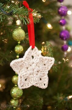 a crocheted star ornament hanging from a christmas tree