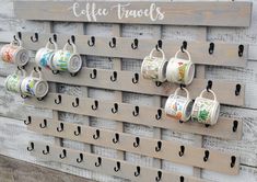 coffee cups are hanging on the wall with hooks