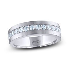 a white gold wedding ring with channeled diamonds on the side and an inscription that reads,