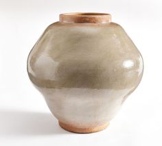 a white and brown vase sitting on top of a table