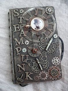 an old book with gears and letters on it's cover is being used as a postcard