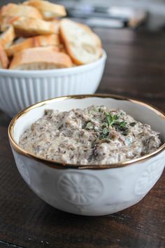 there is a bowl of oatmeal with bread in the background