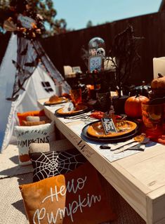 a table set up for halloween with pumpkins and decorations