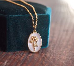 a close up of a gold necklace on a wooden surface with a box in the background