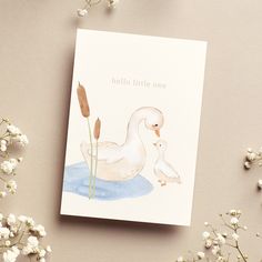 there is a card with a duck and baby duck on it next to some flowers