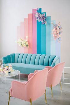 a living room with pastel colored walls and pink chairs in front of the couch