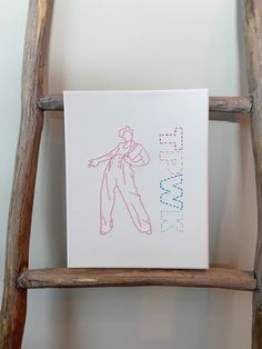 a card with a drawing of a man on it sitting on top of a wooden ladder