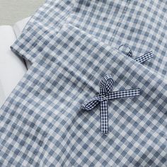 a blue and white checkered shirt with a knot on the front, worn by someone