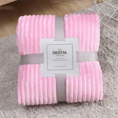 a pink blanket sitting on top of a rug