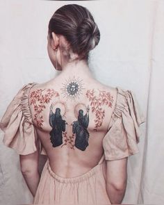 the back of a woman's body with tattoos on her upper and lower back