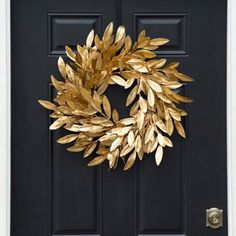 a black door with a gold wreath on it