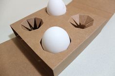 three eggs in a carton on a table