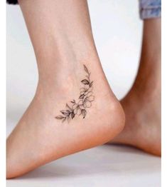 a woman's foot with a small flower tattoo on her left side calfocks