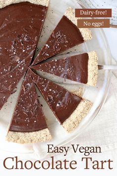 a chocolate pie is cut into slices on a glass platter with a white cloth