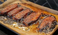 some meat is being cooked in a pan on top of the stove and it looks like they're ready to be eaten