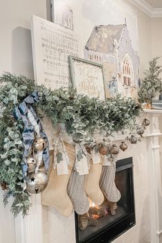 christmas stockings hung on the mantle with greenery