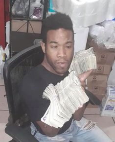 a man sitting in an office chair holding money