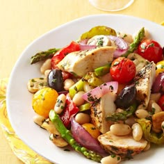 a white plate topped with chicken, beans and veggies