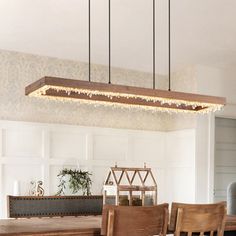 a dining room table and chairs with lights hanging from the ceiling