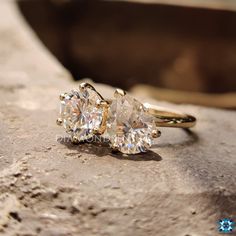 two diamond rings sitting on top of a rock