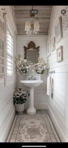 a white sink sitting under a mirror in a bathroom