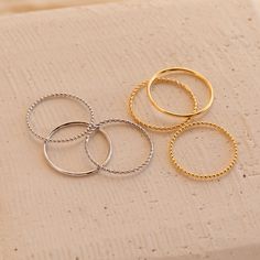 Our Skinny Stacking Rings are the simple and minimalist essentials for creating a dainty, multilayered finger stack that'll be the envy everyone around you. Their slightly textured finish adds a unique touch to the stack, as the trio features a ball, twist, and smooth band. Material: High-Quality Solid 925 Sterling Silver Finish: Sterling Silver ∙ 18K Gold Dimensions: 1mm This listing is for a set of 3 rings: 1 SOLID ring, 1 TWISTED ring, and 1 BEADED ring SKU: RR-RR051 Sizing Guide Rings are cr Trendy Tarnish-resistant Stackable Rings, Minimalist Stacked Rings For Everyday, Minimalist Everyday Stacked Rings, Minimalist Stackable Round Midi Rings, Minimalist Double Band Stackable Rings, Dainty Circle Midi Rings For Everyday, Stacked Minimalist Midi Rings, Minimalist Stackable Rings For Layering, Dainty Stackable Rings With Metal Round Band