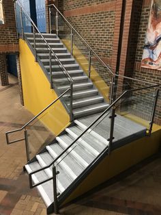 a set of stairs leading up to a brick building with metal railings and handrails