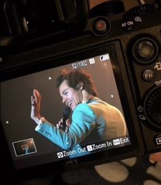 a person holding a camera up to their face with a video on it's screen