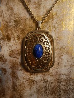 This stunning gold plated locket features a cobalt blue stone in the center and can fit 2 photos inside. It is in excellent condition. Measurements- Bail to end of pendant: 2.5 inches Width: 1.5 inches Chain: 14 inches *ALL ITEMS ARE FINAL SALE AND COME FROM A SMOKE FREE HOME. ITEMS MAY HAVE SCUFFS, ODOR STAINS/MARKS OR HOLES. I DO NOT INSPECT ANY ITEMS SOLD UNLESS INDICATED IN PHOTOS OR DESCRIPTION. ALL ITEMS ARE PURCHASED AS IS AND ARE SOLD AS IS.* Blue Hallmarked Medallion Jewelry, Blue Oval Locket Necklace, Oval Blue Locket Necklace, Formal Blue Locket Jewelry, Blue Engraved Jewelry For Keepsake, Blue Medallion Necklace For Anniversary, Blue Engraved Necklace For Keepsake, Antique Blue Brass Necklace, Antique Blue Brass Jewelry