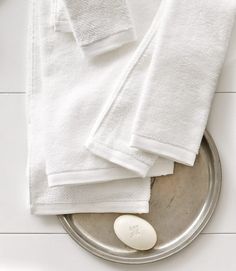 white towels are sitting on top of a silver tray