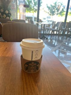 a starbucks cup sitting on top of a wooden table