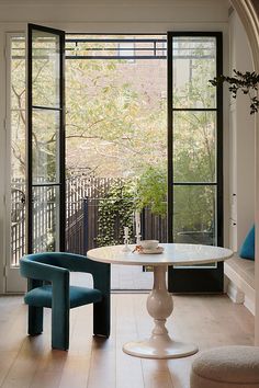 a dining room table with chairs and a bench in front of large glass doors that look out onto the backyard