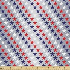 a red, white and blue star pattern on fabric with a ruler in the foreground