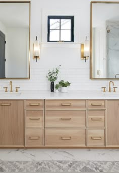 a bathroom with two sinks and mirrors on the wall