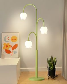 a green floor lamp next to a potted plant