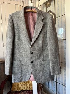 This is a classic registered Harris Tweed jacket, made from 100 per cent wool in light to dark grey. It has the original turtle buttons in the front and on the cuffs, three outside pockets and two inside pockets, and it's fully lined with pinky beige silky lining. The measurements, taken with the jacket lying flat, are: shoulder to shoulder, 18 inches; armpit to armpit, 21 inches; sleeves, 25 1/2 inches; length, 33 inches; bottom edge, 29 inches. In very good condition. Classic Tweed Sport Coat For Business Casual, Classic Wool Sport Coat With Herringbone Pattern, Tailored Gray Wool Tweed Jacket, Gray Wool Tweed Jacket With Notch Lapel, Gray Wool Tweed Jacket, Gray Business Tweed Jacket With Welt Pockets, Gray Tweed Jacket With Welt Pockets For Business, Gray Wool Tweed Jacket For Formal Occasions, Formal Gray Wool Tweed Jacket