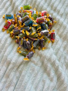 a pile of candy sitting on top of a bed