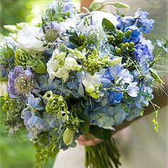 a bride holding a bouquet of blue and white flowers