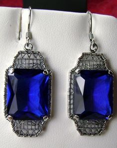 "Simulated Blue Sapphire Earrings Lantern Design#E13 Custom Made Inspired by the Art Deco movement of the early 1900s, I now offer these lovely Antique reproduction earrings in sterling silver. These earrings were refashioned from an Antique Art Deco brooch. Each stunning 9ct Simulated Blue Sapphire is 15mm long (just over 9/16\") and 12mm in width (1/2th\"). The earrings are 1 3/4th inch long and 9/16th at their widest. I often also sell the matching pendant. A gift box is included and all item Blue Rectangular Jewelry For Party, Classic Rectangular Evening Earrings, Art Deco Blue Drop Earrings, Classic Blue Jewelry For Evening, Classic Blue Drop Earrings, Blue Art Deco Drop Earrings, Classic Rectangular Party Earrings, Blue Art Deco Jewelry For Evening, Classic Formal Earrings With Rectangular Stone