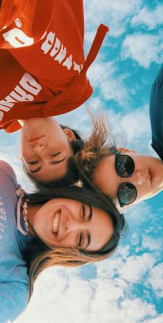 three girls are standing together in the sky