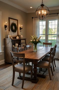 a dinning room table with chairs and a chandelier hanging from the ceiling